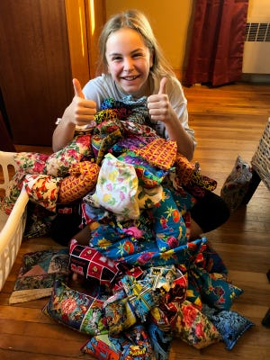 Makenah Cowles poses for a photo with her hand-made Peace Packs.