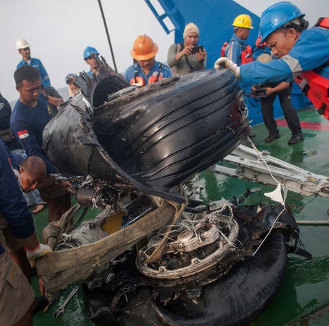 Rescuers inspect part of the landing gears of the...