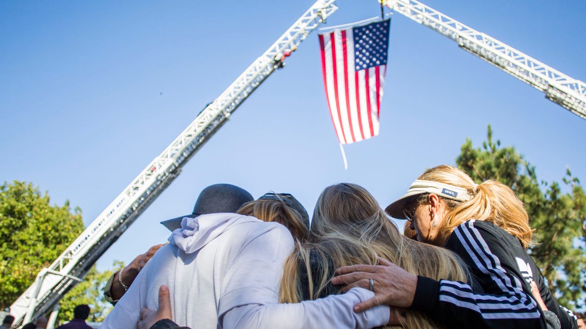 Friends hug outside Los Robles Medical Center in Thousands Oaks, California, paying tribute to Ventura Country Sheriff's Sgt Ron Helus, killed in the shooting at the Borderline Bar in Thousands Oaks on November 08, 2018. - The gunman who killed 12 people in a crowded California country music bar.