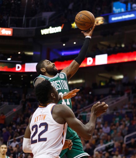 Celtics' Kyrie Irving (11) makes a layup against Suns' Deandre Ayton (22) during the second half at Talking Stick Resort Arena in Phoenix, Ariz. on November 8, 2018.