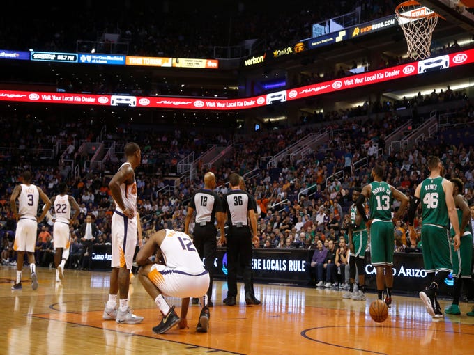Suns TJ Warren (12) bends down after a flagrant one foul on Celtics' Marcus Morris (13) during the first half at Talking Stick Resort Arena in Phoenix, Ariz. on November 8, 2018. 