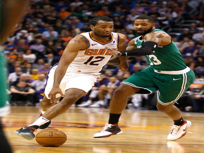 Suns' TJ Warren (12) drives against Celtics' Marcus Morris (13) during the first half at Talking Stick Resort Arena in Phoenix, Ariz. on November 8, 2018. 