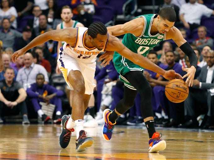 Suns' TJ Warren (12) attempts to steal a ball away from Celtics' Jayson Tatum (0) during the first half at Talking Stick Resort Arena in Phoenix, Ariz. on November 8, 2018. 