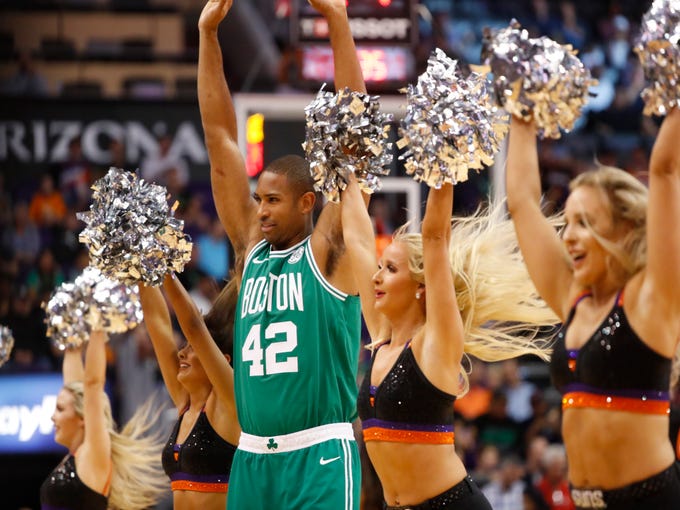 Celtics' Al Horford (42) stretches as the Suns cheerleaders dance during the first half at Talking Stick Resort Arena in Phoenix, Ariz. on November 8, 2018.