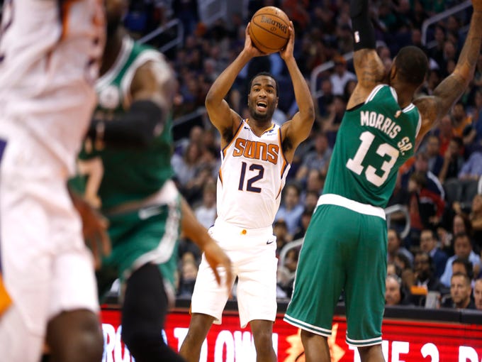 Suns' TJ Warren (12) looks for teammates while being defended by Celtics Marcus Morris (13) during the first half at Talking Stick Resort Arena in Phoenix, Ariz. on November 8, 2018. 