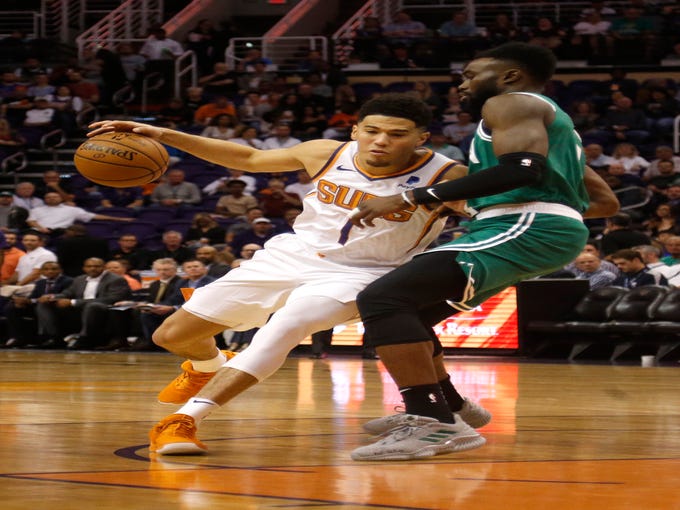 Suns' Devin Booker (1) drives against Celtics' Jaylen Brown (7) during the first half at Talking Stick Resort Arena in Phoenix, Ariz. on November 8, 2018.