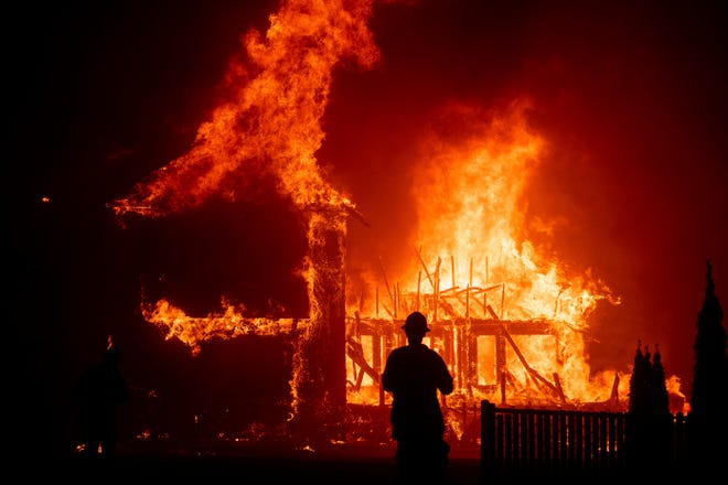 A home burns as the Camp Fire rages through Paradise, Calif., on Nov. 8, 2018. 
