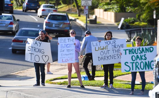 Signs of support greet motorists at a busy intersection in Thousand Oaks, Calif. on Nov. 8, 2018.