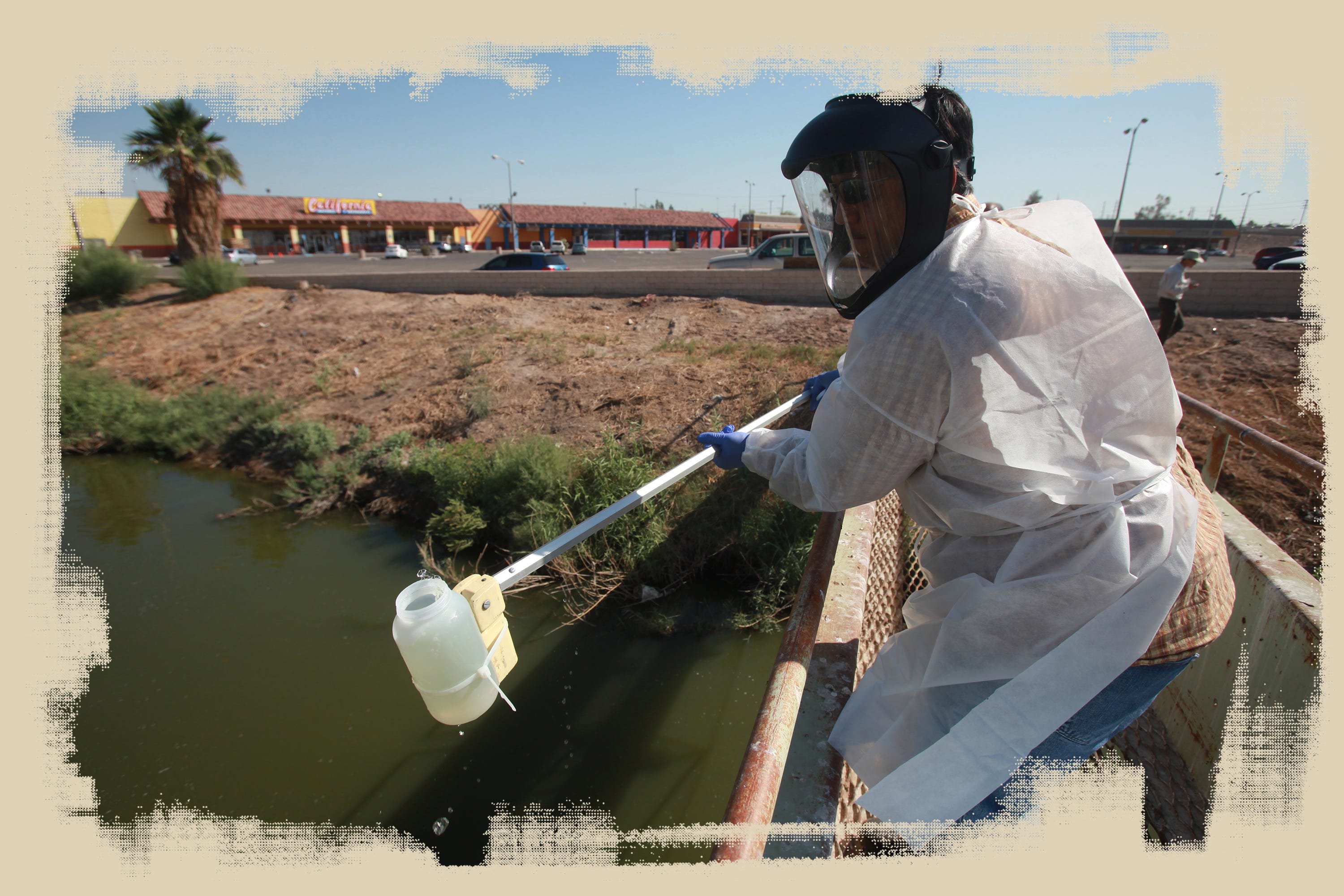 An employee of the California Regional Water Quality Control Board takes a water sample from the New River in Calexico.