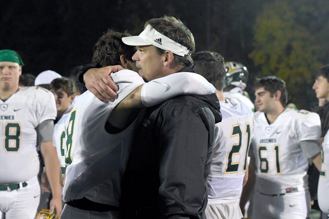 Christ School quarterback Navy Shuler gets a hug from his dad, Heath, after the Greenies lost 43-14 in the NCISAA Division I State Championship game at Charlotte Christian School on Nov. 9, 2018.