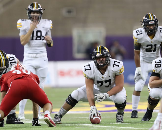 Southeast Polk's Aaron Martinez (77) prepares to make the snap to quarterback Josiah Cole (18) in a Nov. 9 state semifinal against Cedar Falls at the UNI Dome.