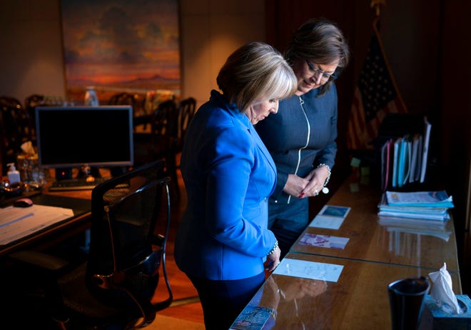 New Mexico Gov. Susana Martinez, right, and U.S. Rep. Michelle Lujan Grisham, who was elected Tuesday as the state's next governor, talk about memorabilia surrounding the Governor's desk during a meeting at the State Capitol in Santa Fe, N.M., on Friday, Nov. 9, 2018. Martinez, a Republican and the state's first female governor, has served two consecutive terms. Lujan Grisham, a Democrat, will take office Jan. 1, 2019.