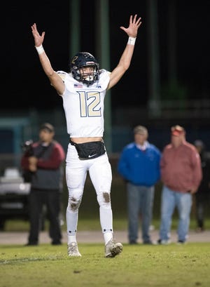 Gulf Breeze High School’s Cooper Harris, (No. 12) signals the team's first touchdown of the game during Friday night’s playoff against Pine Forest High School.
