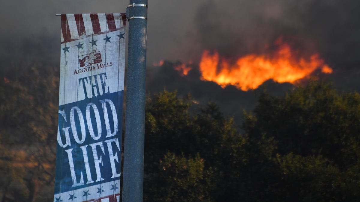 Flames send smoke into an Agoura Hills neighborhood in California on Nov. 9, 2018. The Woosley Fire in Ventura County has grown to over 35,000 acres and forced the evacuation of many residents.