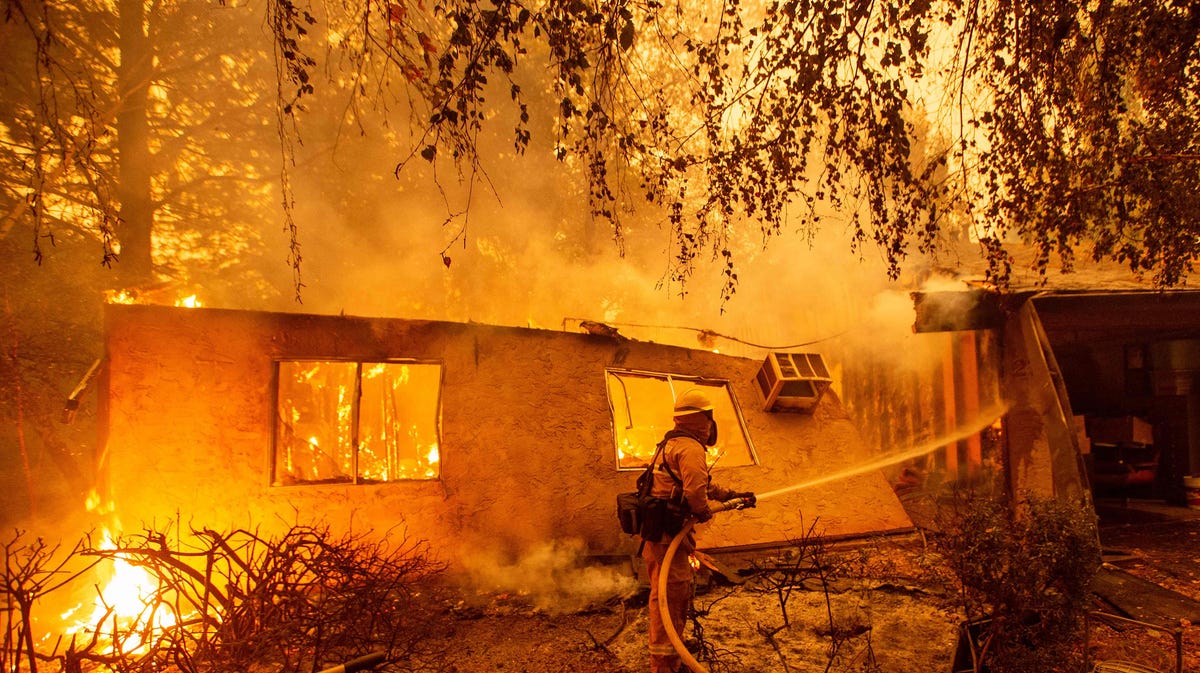 Firefighters battle flames at a burning apartment complex in Paradise, north of Sacramento, Calif. on Nov. 09, 2018. A rapidly spreading, late-season wildfire in northern California has burned 20,000 acres of land and prompted authorities to issue evacuation orders for thousands of people. As many as 1000 homes, a hospital, a Safeway store and scores of other structures have burned in the area as the Camp fire tore through the region. 