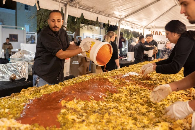 Dickerson's Catering employees mix nacho ingredients together at Noche de Nachos. Las Cruces unofficially set the record for world's largest serving of nachos Saturday, Nov. 10, 2018, in downtown Las Cruces.