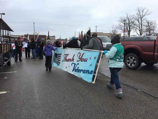 Girl Scouts carry a banner thanking servicemembers before the Veterans Day Parade, Nov. 11, 2018 in St. Cloud.