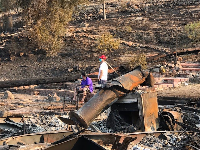 Residents of Oak Forest Estates in Westlake Village and their friends survey the rubble left behind Saturday by the Woolsey Fire. Some residents estimated 25 homes were destroyed or damaged by the blaze.