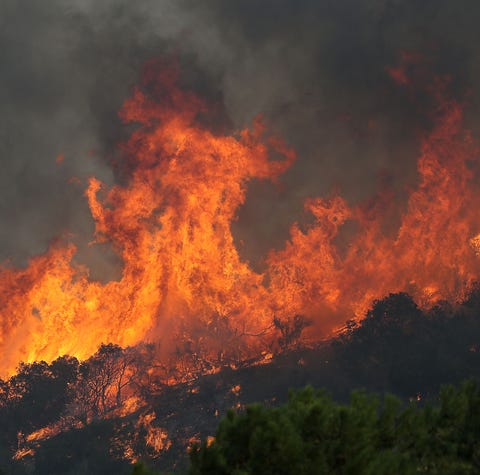 Flames from the Woolsey Fire threaten hillside...