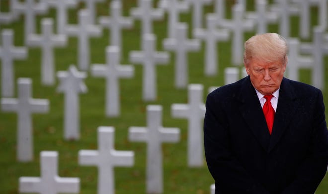 President Donald Trump stands in front of headstones at Suresnes American Cemetery near Paris on Sunday, Nov. 11, 2018.