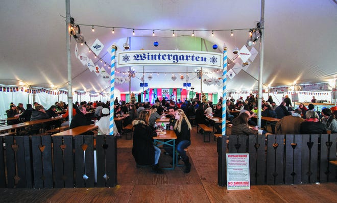 Visitors enjoy delicious food and drink in the Wintergarten tent at The German Christmas Market in Oconomowoc.