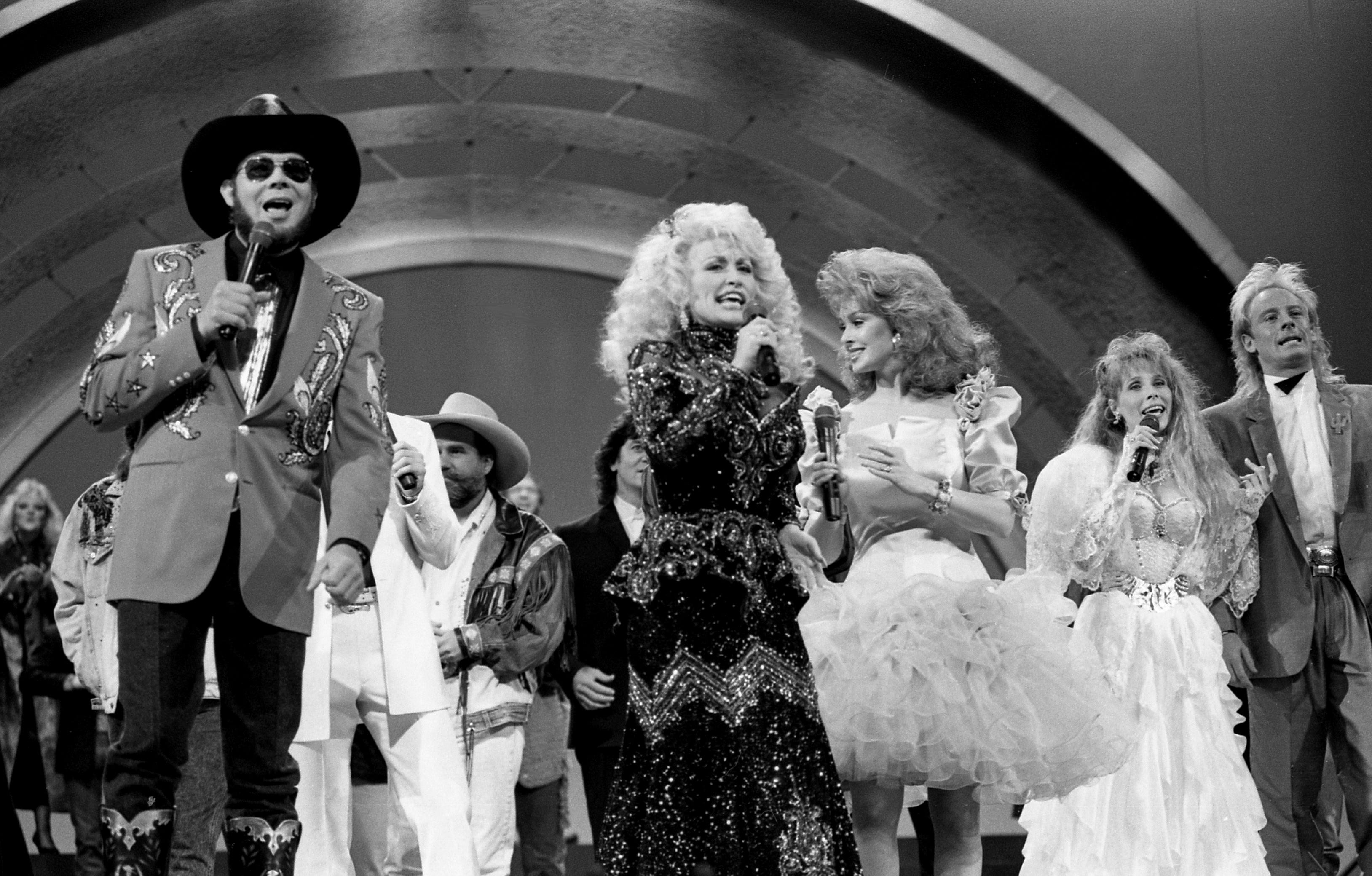 Host Dolly Parton sings with other county-music stars in the opening number of the CMA Awards show at the Grand Ole Opry House in 1988.