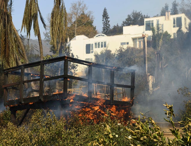 A deck burns at a home on Harvester Road in Malibu after the Woolsey Fire overran the neighborhood.