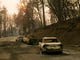 Vehicles sit pushed off the road days after the Camp Fire swept through town on Nov. 11, in Paradise, Calif.