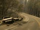 Vehicles sit pushed off the road days after the Camp Fire swept through town on Nov. 8 in Paradise.