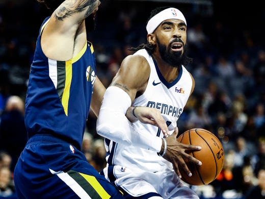 Memphis Grizzlies guard Mike Conley drives the lane against Utah Jazz defender Ricky Rubio (left) during action at the FedExForum in Memphis, Tenn., Monday, November 12, 2018.