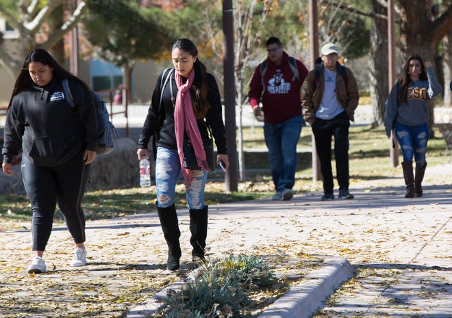 New Mexico State University Students wearing hats, jackets, scarves and gloves walk across campus as a cold snap caused a freeze warning, Tuesday November 13, 2018.