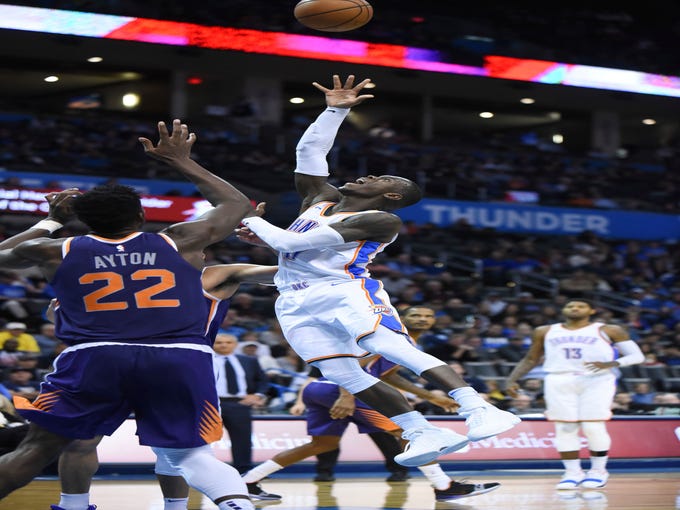 Oklahoma City Thunder guard Dennis Schroder (17) goes up for a shot over Phoenix Suns center Deandre Ayton (22) in the second half of an NBA basketball game in Oklahoma City, Monday, Nov. 12, 2018.