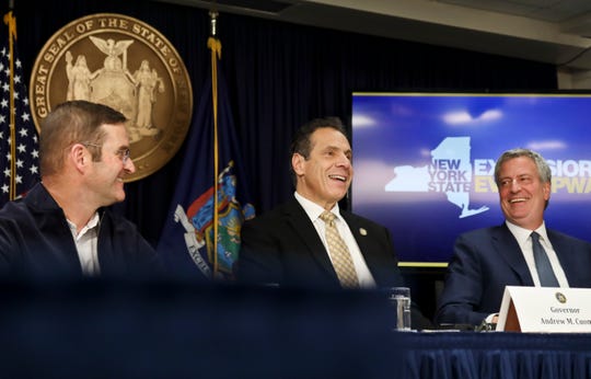 John Schoettler, Amazon vice president for real estate and facilities, left, joins New York Gov. Andrew Cuomo, center, and New York City Mayor Bill de Blasio during a news conference Tuesday Nov. 13, 2018, in New York.  (AP Photo/Bebeto Matthews)