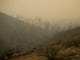 A cross looks over a valley filled with smoke from the Camp Fire on Nov. 12, in Butte Valley, Calif.