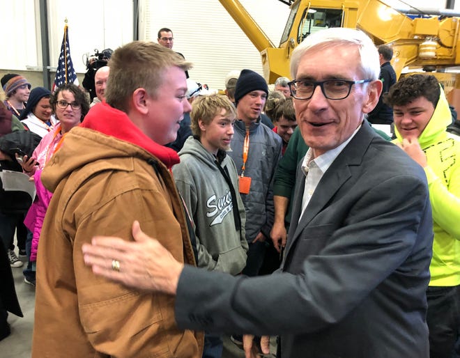 Gov.-elect Tony Evers pats the arm of Edgerton High School sophomore Colin Bowen, left, at an event in the Wisconsin Operating Engineers' training center in Coloma on Wednesday. Bowen told Evers he stayed up all night Nov. 6 to wait until Evers' race was called. "Did you go to school the next day?" Evers responded. 