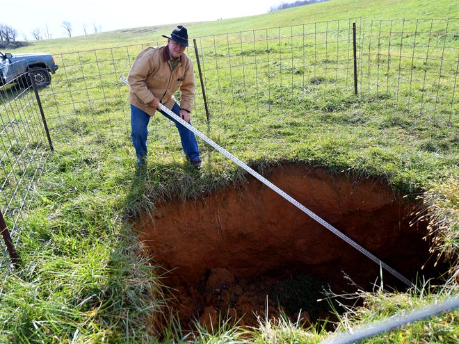 Bobby Whitescarver, an Augusta County farmer and soil conservationist, uses a surveyors rod to measure a sinkhole on Scott Miller's farm in Swoope. He investigates the sinkhole, which is 2.6 miles from the route for the proposed Atlantic Coast Pipeline, at the request of his neighbor on Wednesday, Nov. 14, 2018. 