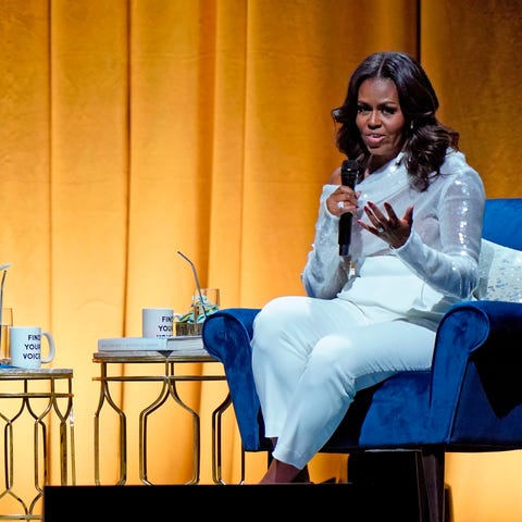 Former US first lady Michelle Obama (R) and Oprah...