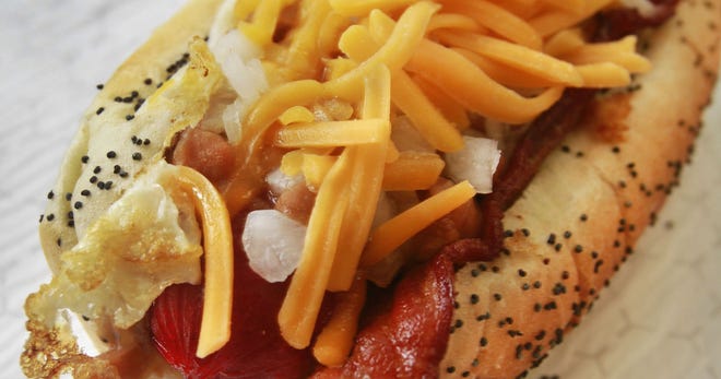This King David hot dog is served up on a baked poppy seed bun and loaded with baked beans, fried egg, thick-cut bacon, chopped onion and shredded cheese.