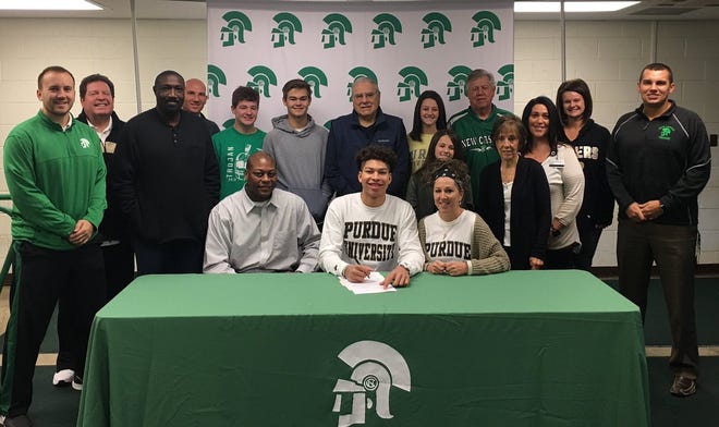 New Castle star Mason Gillis signs his letter of intent to attend Purdue University while surrounded by family, coaches and teammates.