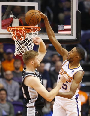 Phoenix Suns forward Mikal Bridges (25) scores a basket while being guarded by San Antonio Spurs forward Davis Bertans (42) during a NBA game at Talking Stick Arena in Phoenix on November 14.