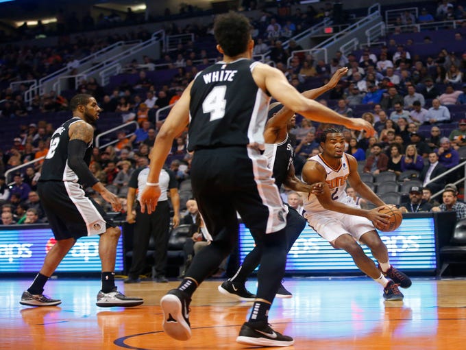 Phoenix Suns forward TJ Warren (12) dribbles the ball while being guarded by  San Antonio Spurs forward Dante Cunningham (33) during a NBA game at Talking Stick Arena in Phoenix on November 14.  