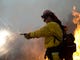 Firefighter Ross Miller fires an incendiary round into a fire line in the Camp Fire as part of a control burn Near Bloomer Hill in Butte County in California on Nov. 14, 2018. 