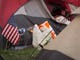 An American flag sits next to a tent in a make-shift compound in the Walmart parking lot in Chico, CA. Many of the people camping there do not know if they have a home to return to or not.