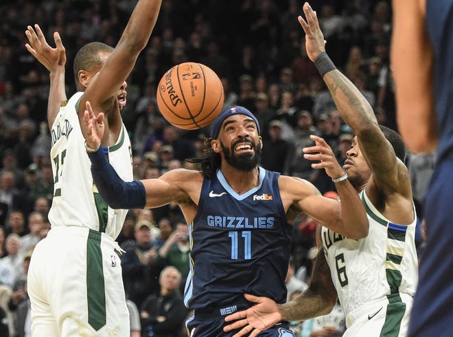Grizzlies guard Mike Conley (11) battles for a loose ball between Bucks forward Khris Middleton (22) and guard Eric Bledsoe (6) in the fourth quarter Nov. 14, 2018, at Fiserv Center.