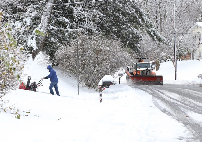 Tassos Katsetos uses his snowblower as a Town of Poughkeepsie plow clears the road in theTown of Poughkeepsie on November 16, 2018.