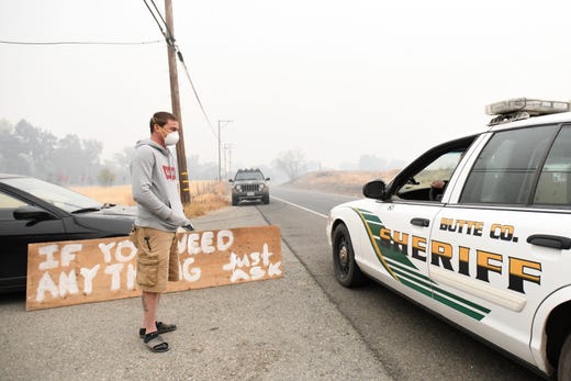 Well inside the evacuation zone surrounding the California town of Paradise, resident Chris Jones thanks a Butte County sheriff's deputy for the work she and other first responders are doing. Jones is one of the few still living inside the evacuation zone.