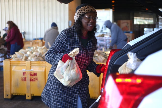 A volunteer loads bags of food into a trunk as Farm Share provides roughly 1,000 meals for families in Quincy around Thanksgiving. Farm Share is offering food the those hurt by the government shutdown.