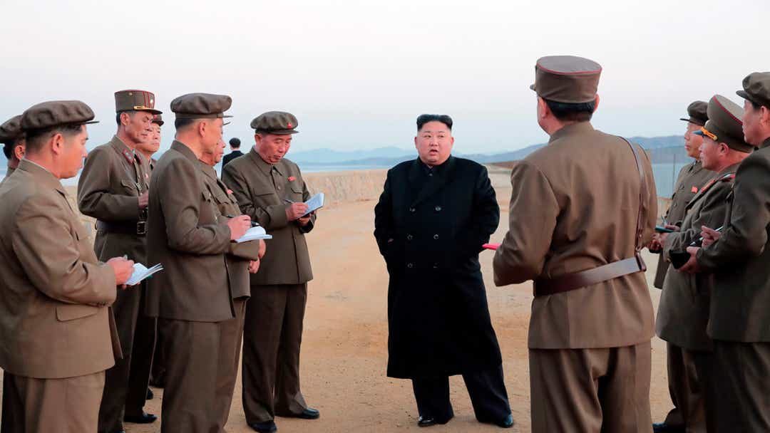 In this undated photo released Friday by the North Korean government, Kim Jong Un, center, listens to a military official as he inspects a weapon testing at the Academy of National Defense Science, North Korea.