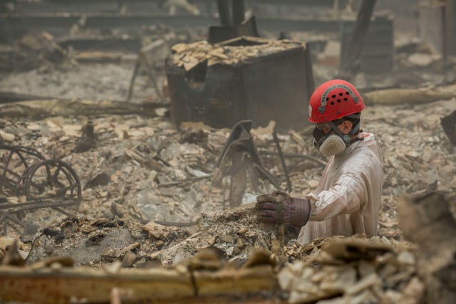 Search and rescue personnel comb through debris searching for remains in a neighborhood near Pentz Road in Paradise, CA, after the Camp Fire devastated the area.