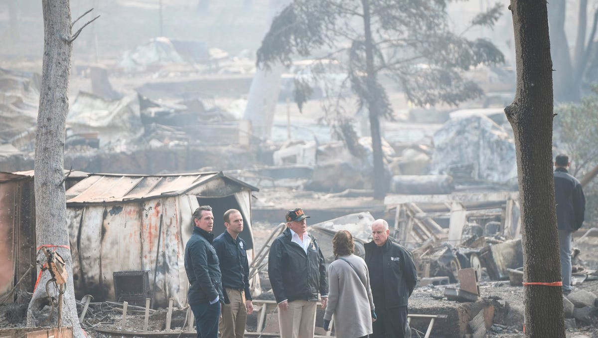 President Donald Trump, center, looks on with Paradise Mayor Jody Jones (2R),  Governor of California Jerry Brown (R), Administrator of the Federal Emergency Management Agency, Brock Long (2L), and Lieutenant Governor of California, Gavin Newson, as they view damage from wildfires in Paradise, Calif. on Nov. 17, 2018.  President Donald Trump arrived in California to meet with officials, victims and the "unbelievably brave" firefighters there, as more than   1,000 people remain listed as missing in the worst-ever wildfire to hit the US state. 